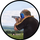 A man shoots a gun on skeet